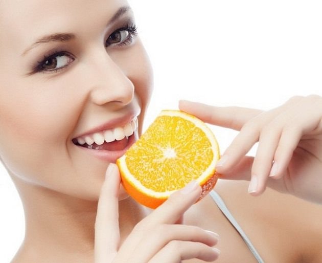 Девушка ест апельсин